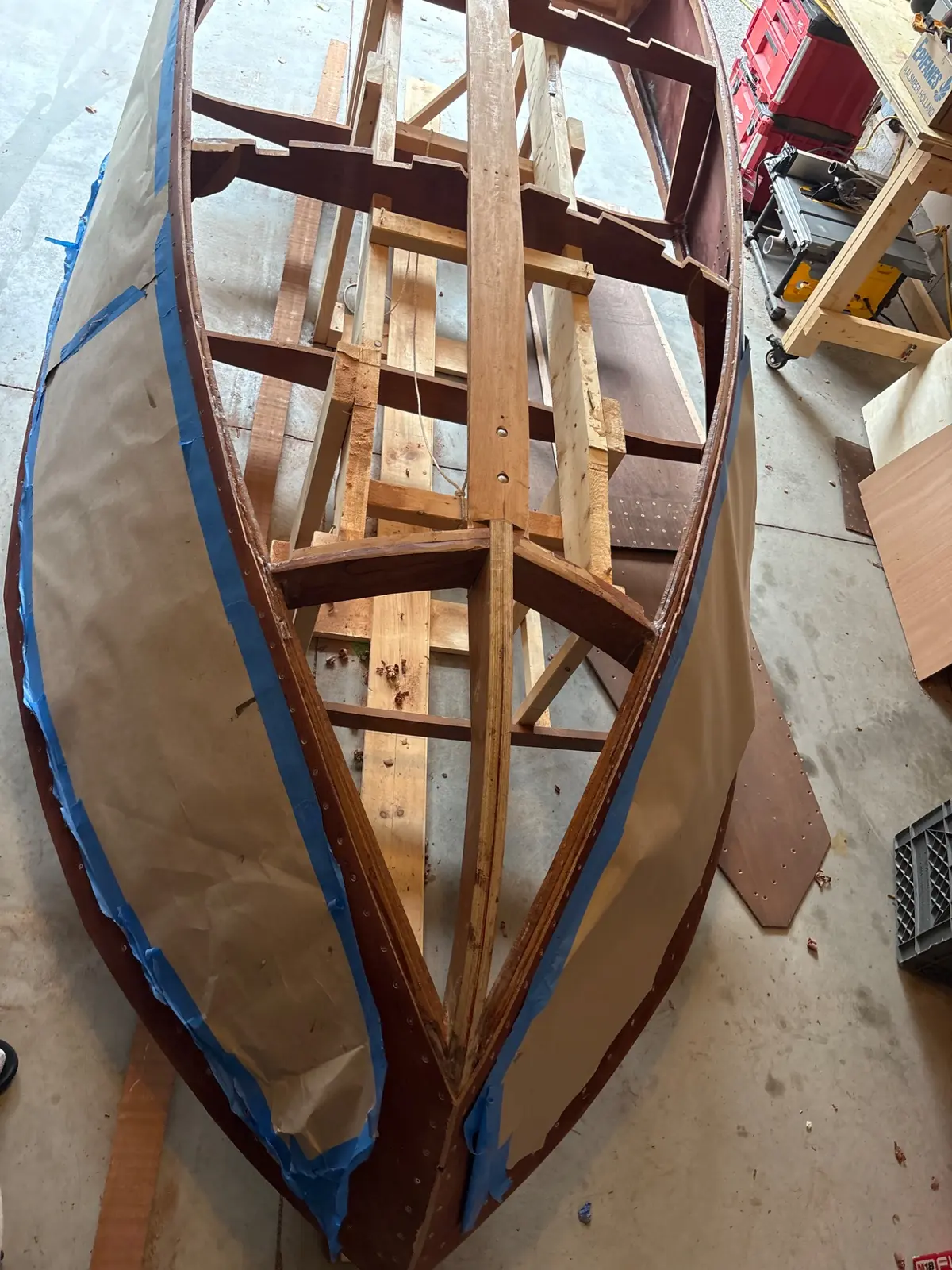 Upside-down Glen-L Flying Saucer hull in a garage with its frames, keel, battens and first side panels on