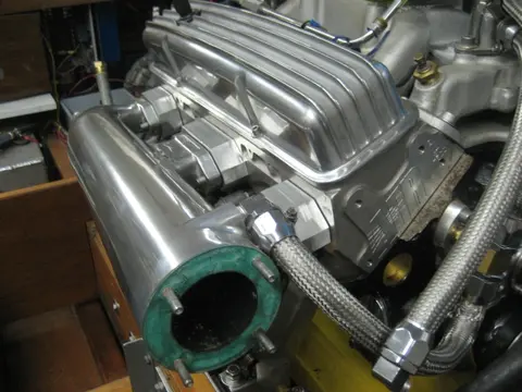 Hot Rod: Exhaust: To help tune our carbureted engine, we fabricated aluminum spacer blocks to mount a wideba