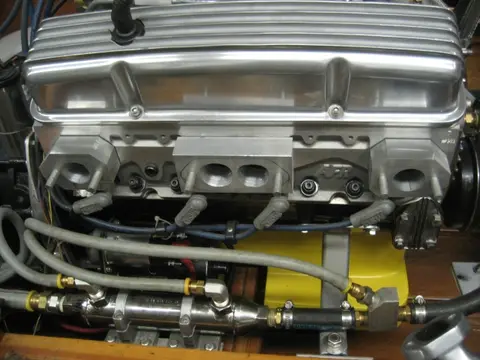 Hot Rod: Exhaust: To help tune our carbureted engine, we fabricated aluminum spacer blocks to mount a wideba