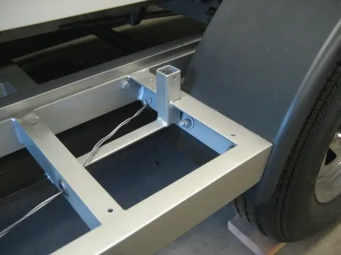 Hot Rod: Trailer: We welded a square tube stub into the fender step to receive a removable boat guide on the